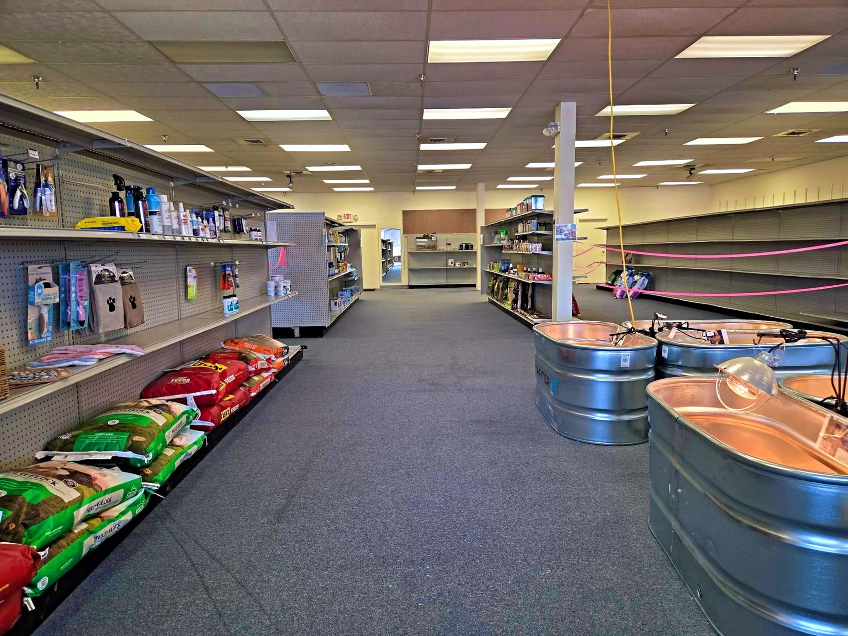 A wide, bright aisle of pet supplies inside Tails & Trails